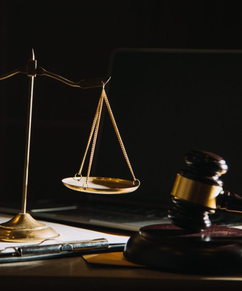 law books and scales of justice on desk in library of law firm. jurisprudence legal education concept.