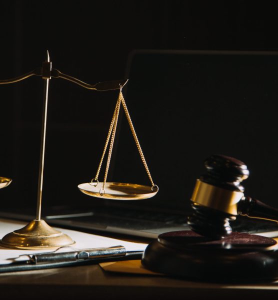 law books and scales of justice on desk in library of law firm. jurisprudence legal education concept.